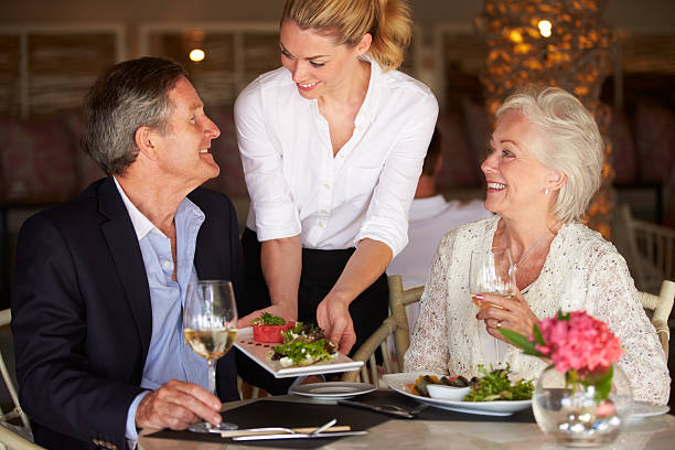 Waitress Serving Food To Senior Couple Waitress Serving Food To Senior Couple